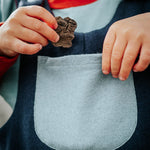 Child holding a rock with a focus on the rock and child's hands