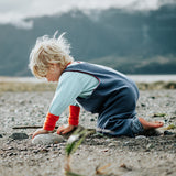 Child playing on a beach with mountains in the background